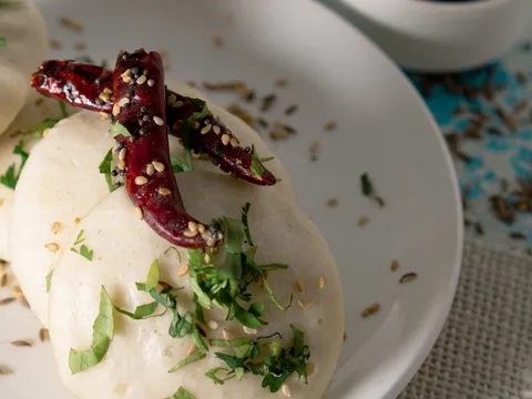 Squares of steamed besan dhokla with a tempering
